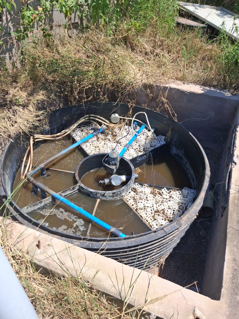 Circular biological reactor filled with white MBBR bio-media carriers and aeration piping